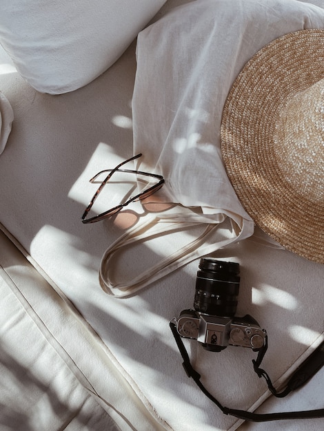 female sunglasses straw hat shopper bag retro photo camera white lounge couch with pillows 408798 9170