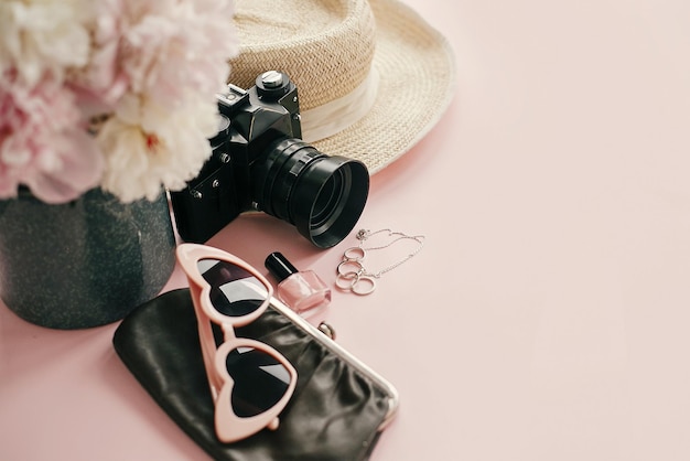 international women s day stylish girly image pink peonies photo camera retro sunglasses jewelry nail polish hat purse pastel pink paper with copy space hello spring concept 250813 5238
